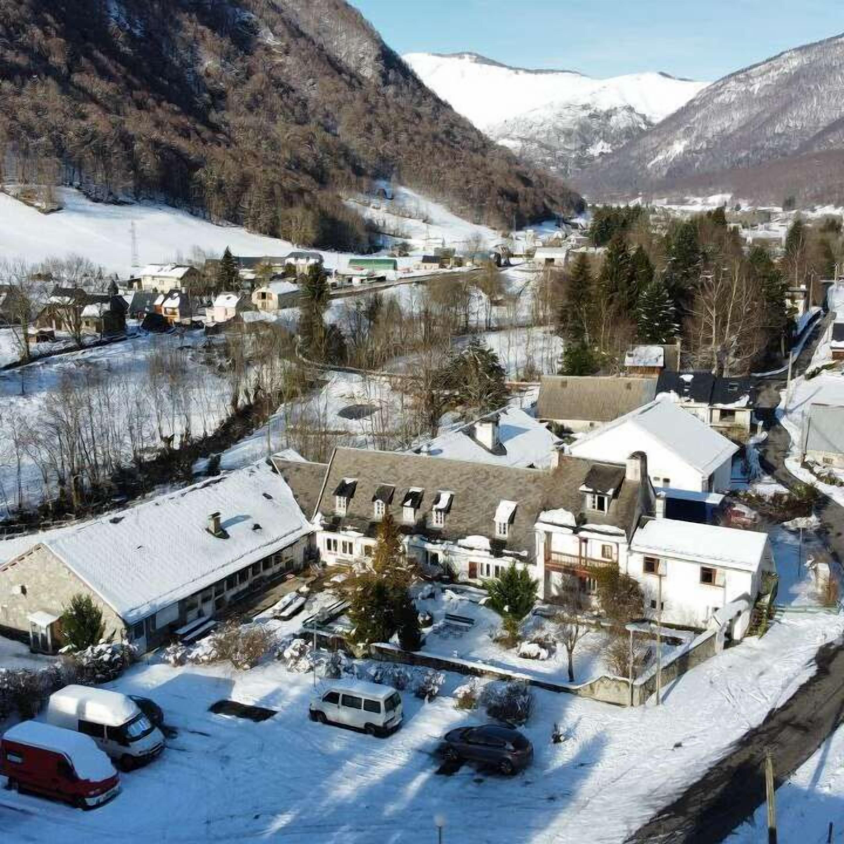 A small town with snow-covered buildings and a mountainous backdrop.