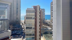 Un immeuble de grande hauteur, doté de nombreux étages, de grandes fenêtres et offrant une vue sur la mer.