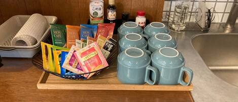 Un comptoir de cuisine sur lequel se trouve un plateau contenant divers aliments, notamment des collations emballées, du café et des condiments.
