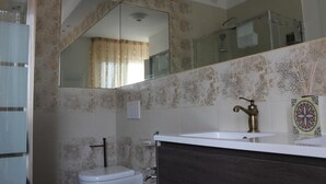 Een badkamer met toilet, wastafel en douche.