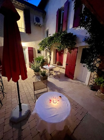 Terrace/patio. Renovated Provencal studio, in the heart of the village of Eyragues, beautiful flower-filled courtyard