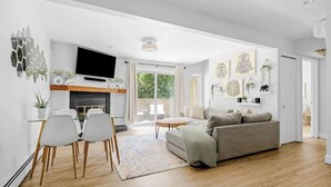 A modern living room with a sofa, TV, and dining area. - Bright & Modern | King Suite | Creekside Trail (Boulder)