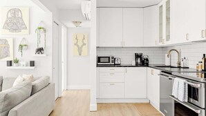 A modern kitchen with white cabinets, a grey countertop, and stainless steel appliances. - Bright & Modern | King Suite | Creekside Trail (Boulder)