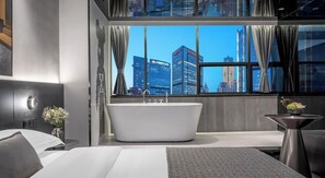 A modern hotel bathroom with a freestanding bathtub, a large window with curtains, and a city view. - Chongqing Jetbear Hotel (Chongqing)
