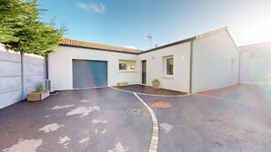 Un garage residenziale con tetto in tegole, un muro in cemento e una piccola finestra.