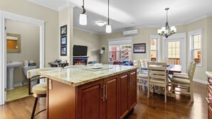 A spacious kitchen with a large island, wooden cabinets, and a fireplace.