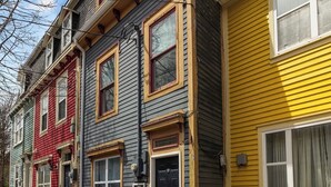 A row of multi-story houses with distinct architectural styles and colors.