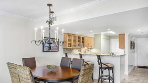 Ein Essbereich mit rundem Tisch und Stühlen, einer Chandelier und Holzschränken im Hintergrund.