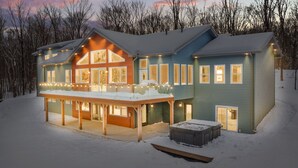 A two-story house with a covered porch and a snow-covered yard.