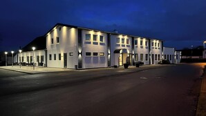 Un edificio moderno con tetto piatto, numerose finestre e un ingresso coperto.