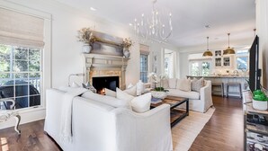 A spacious living room with a fireplace, a dining area, and a kitchen. - Southern Breeze | Easy Beach Access & Private Pool (Inlet Beach)