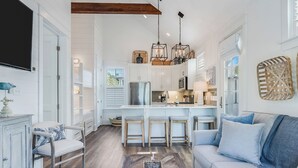 A spacious living room with a light blue sofa, a wooden coffee table, and a TV mounted on the wall. - Southern Breeze | Easy Beach Access & Private Pool (Inlet Beach)