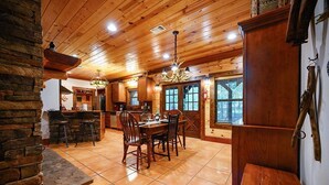 Un intérieur en bois comprenant un coin repas, une cuisine et des éléments décoratifs en pierre.