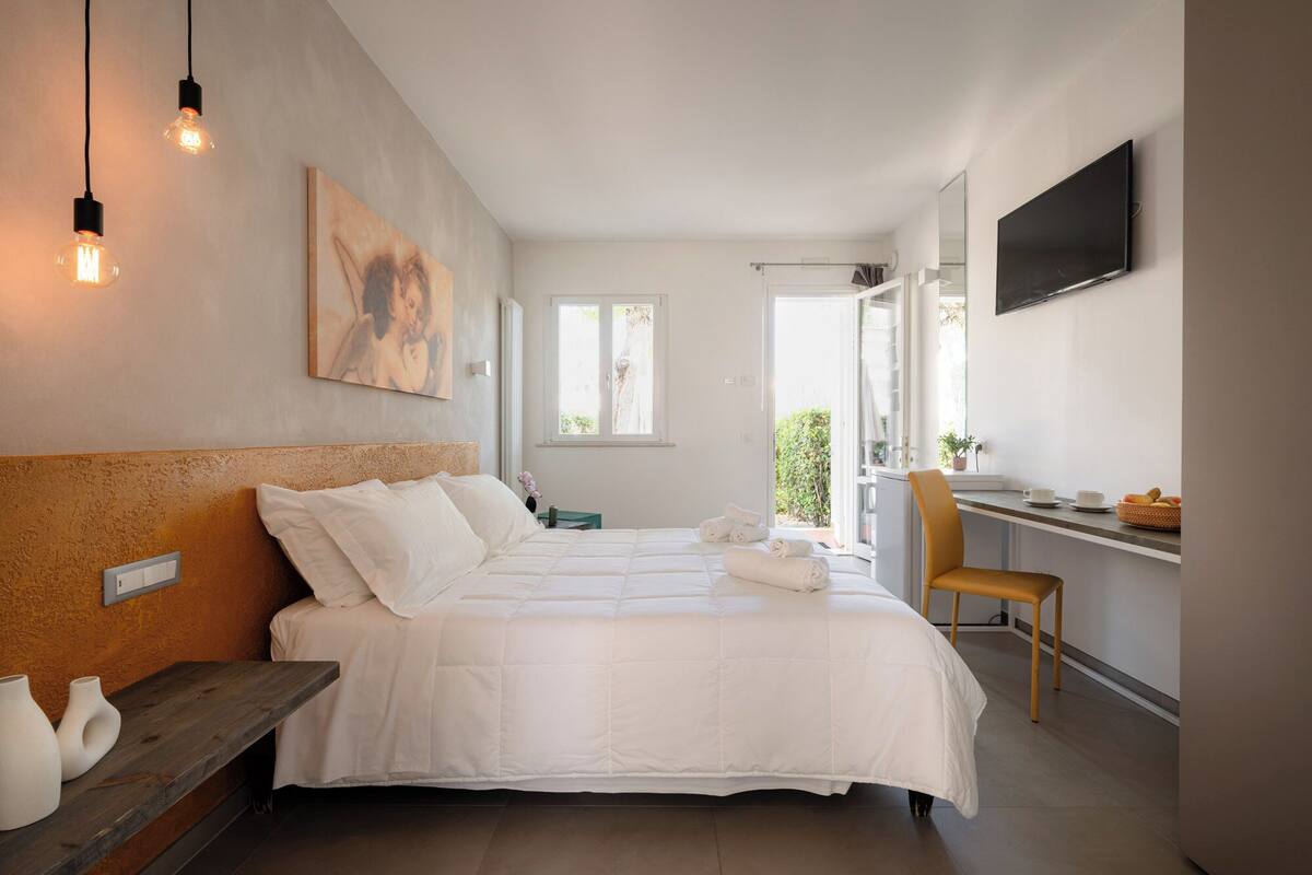 Une chambre moderne avec un grand lit, un bureau et une télévision.