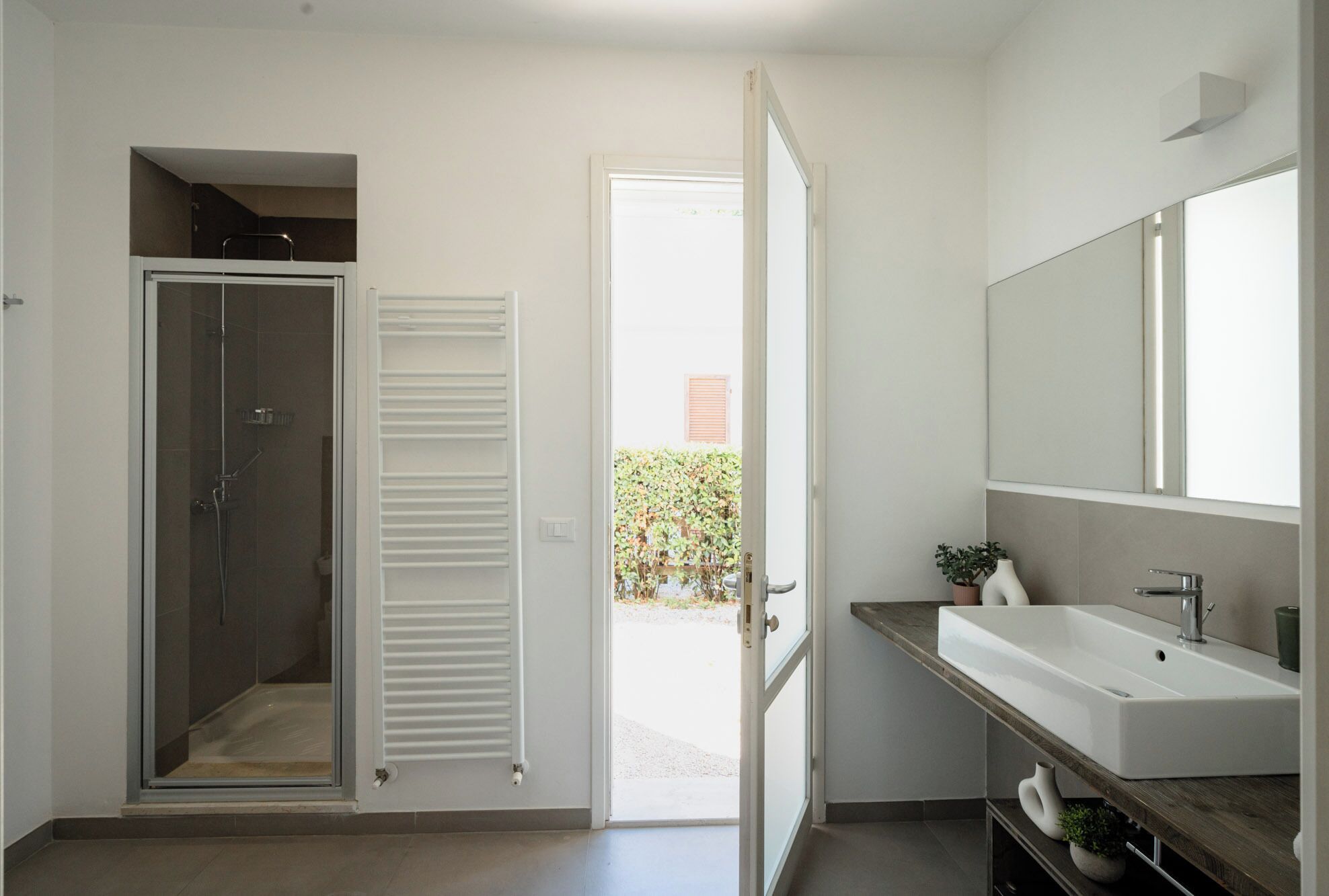 A modern bathroom with a shower, a sink, and a mirror.