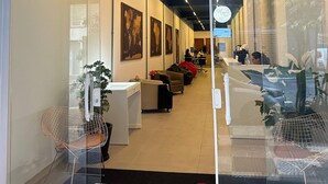 The entrance of a hotel named Treviso with a reception desk, seating area, and world maps on the walls. - TrevizZo Borba Gato (São Paulo)