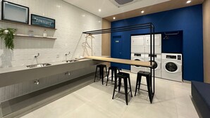 A modern kitchen with a built-in washing machine and a sink. - TrevizZo Borba Gato (São Paulo)