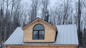 A log cabin with a gabled roof, a large arched window, and two garage doors. - Charming 2-bedroom apartment in marvelous Bethlehem with WiFi (Bethlehem)