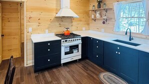 A compact kitchen with wooden walls, a stove, oven, and a sink. - Charming 2-bedroom apartment in marvelous Bethlehem with WiFi (Bethlehem)