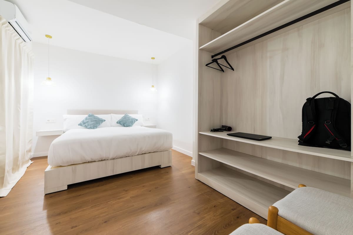 A bedroom with a bed, a wardrobe, and a desk.