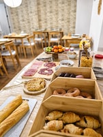 Una mesa de buffet con diversos alimentos, incluyendo carnes, pasteles y frutas.