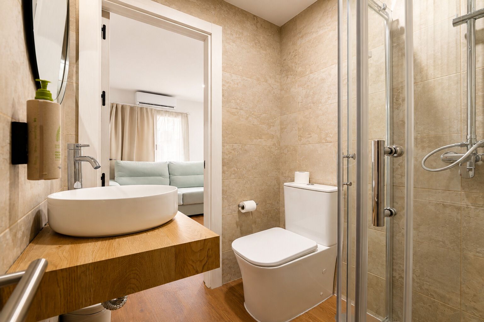 A modern bathroom with a large sink, toilet, and glass shower enclosure.