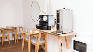 Una cocina moderna con cafetera, microondas y muebles de madera.