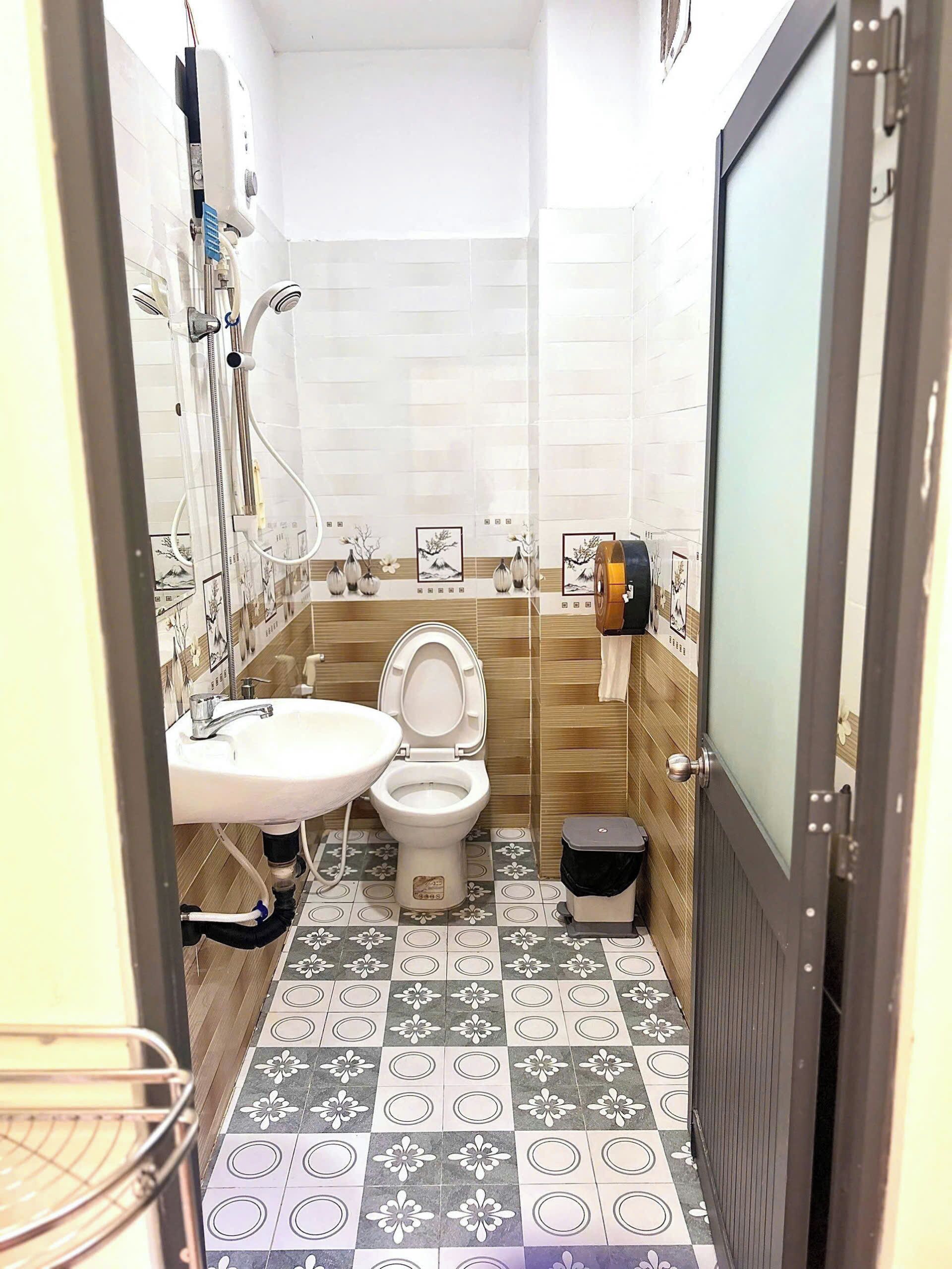 A small bathroom with a toilet, sink, and shower.