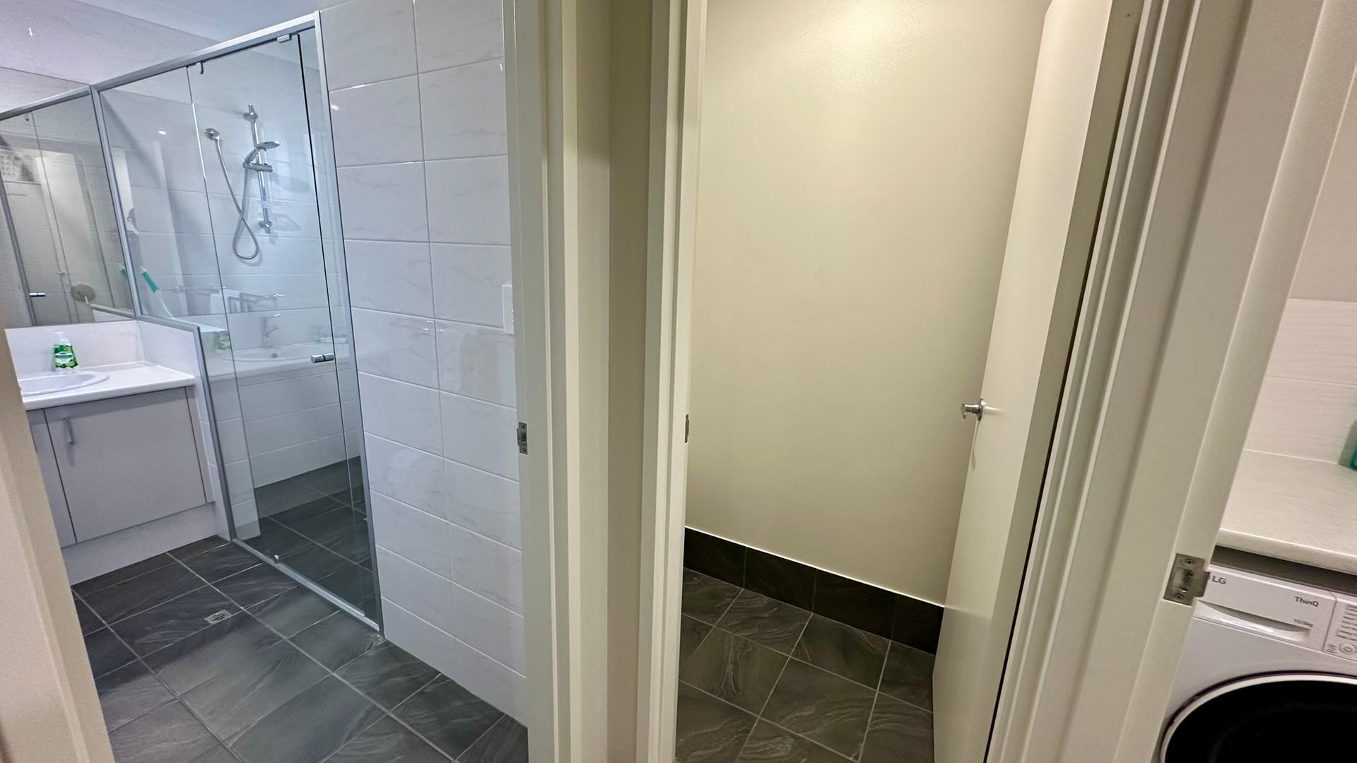 A modern bathroom with a glass shower enclosure, a sink, and a toilet.