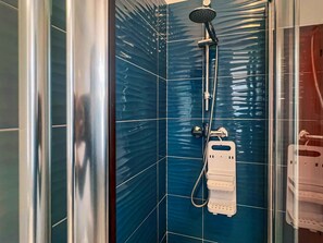 A shower with a handheld showerhead and a wall-mounted faucet. - Holiday apartment with terrace and air conditioning (San Michele al Tagliamento)