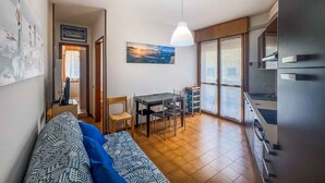 A compact living space with a dining area, kitchenette, and a large window with a view.