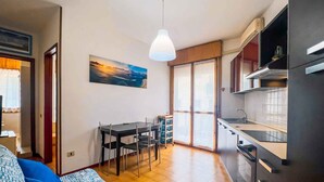 A compact living space with a dining area, kitchenette, and a large window with a view.