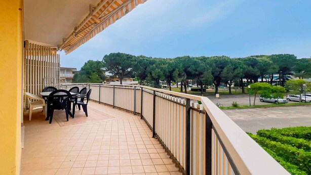 A balcony with a tiled floor, a railing, and a table with chairs.