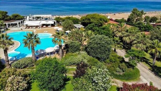 A resort with a swimming pool surrounded by lush greenery and a view of the ocean. - Holiday home mit Terrasse und Klimaanlage (Santa Maria di Castellabate)
