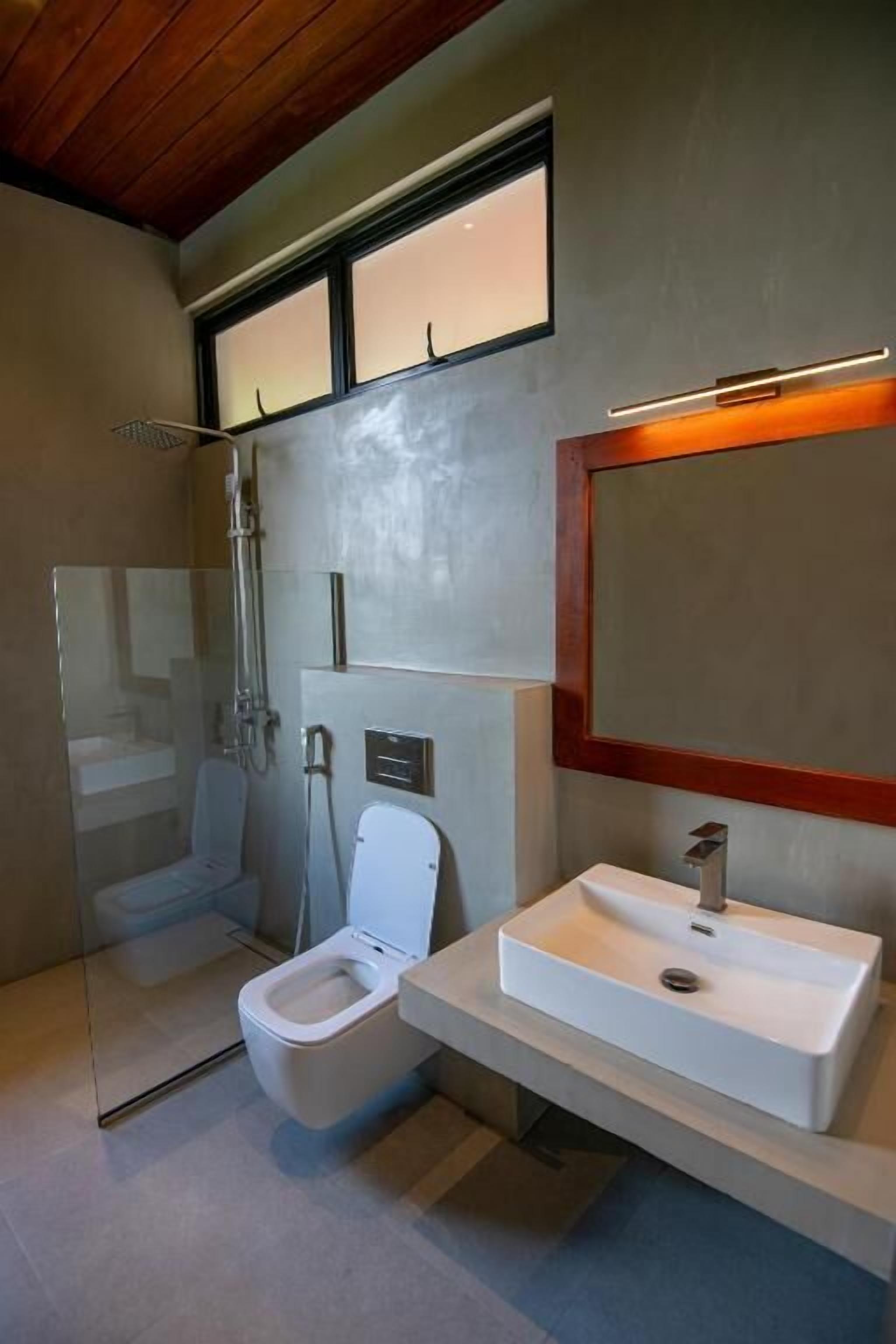 A modern bathroom with a toilet, sink, and shower.