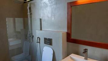 A modern bathroom with a toilet, sink, and shower.