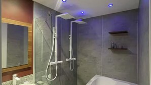 A modern bathroom with a freestanding bathtub, a glass-enclosed shower, and a vanity with a sink.