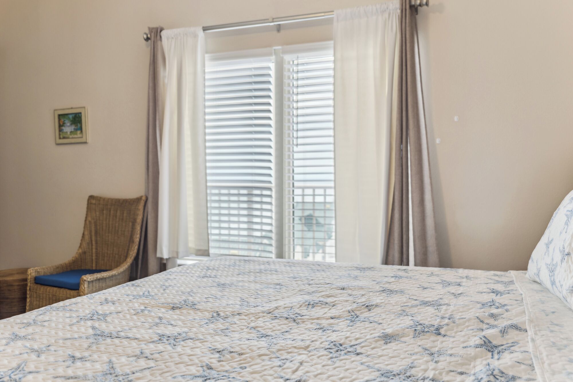 Une chambre à coucher avec un lit, une chaise et une fenêtre équipée de stores.