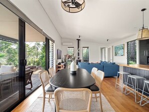 Un intérieur moderne comprenant un coin repas, un canapé bleu et une cuisine.