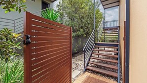 A gated entrance with a wooden gate, a staircase leading to a covered area, and a building with a modern design. - Arbre Retreat—Serene Bushland Escape Near Beach (Dunsborough)