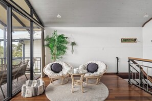Un interior moderno con sillas de mimbre, una mesa redonda y una planta en maceta.