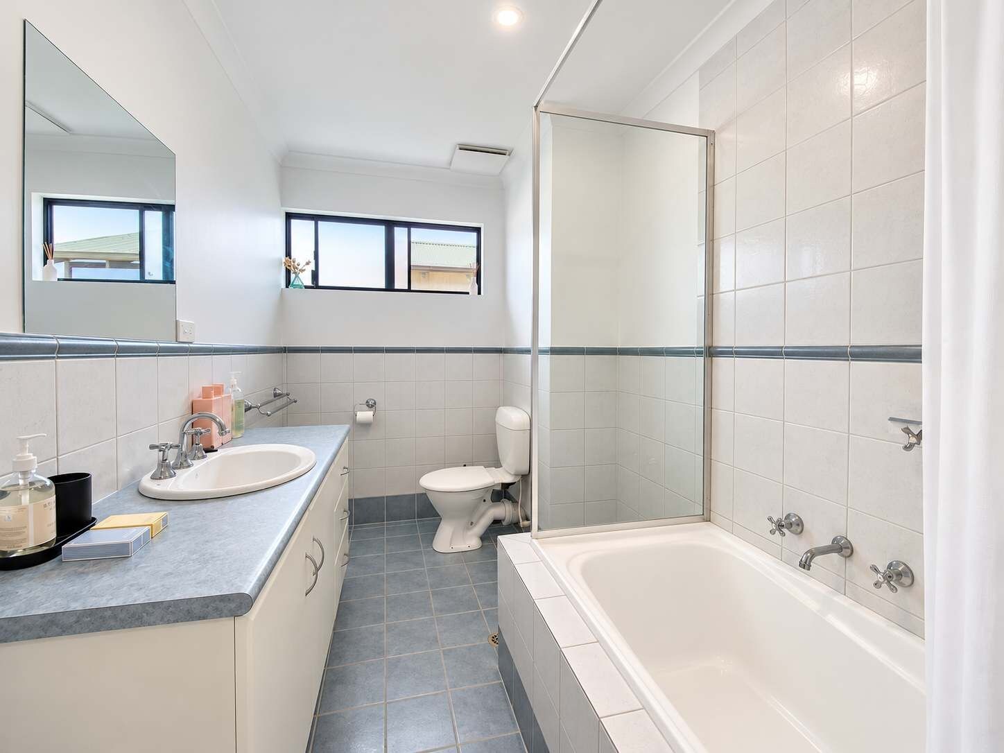 A modern bathroom with a bathtub, toilet, and sink.