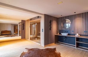 A modern bathroom with a wooden vanity, a round mirror, and a glass shower enclosure. - Chalet Le Rokh - Luxury ski in/out chalet in Peisey&Vallandry (Landry)