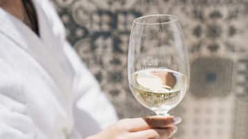 A person in a white robe holding a wine glass.