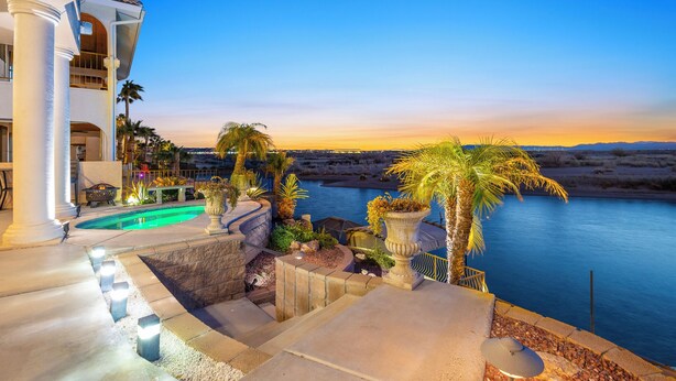 A pool area with a view of the water and mountains at sunset. - Paradise Riverfront Home with Spa and Dock Sleeps 16+ (Bullhead City)