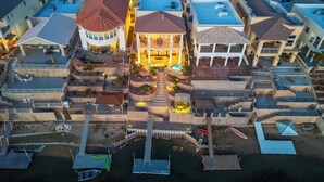 An aerial view of a residential complex with multiple houses, a central courtyard with a swimming pool, and a dock with boats. - Paradise Riverfront Home with Spa and Dock Sleeps 16+ (Bullhead City)