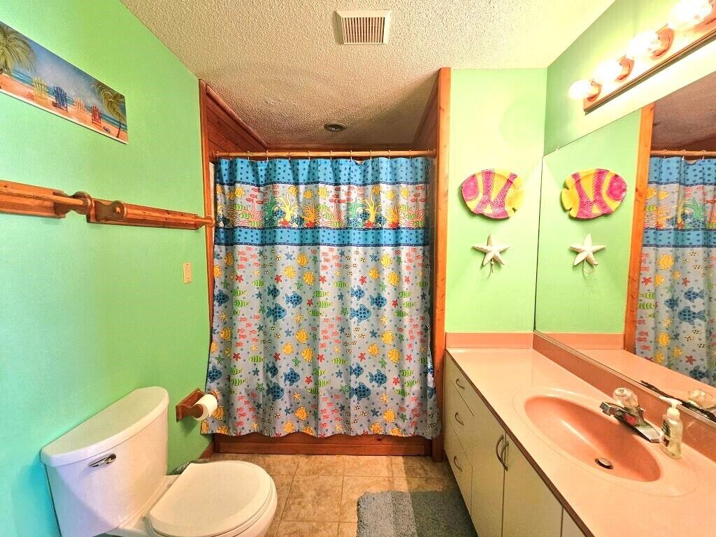 Een badkamer met toilet, wastafel en douchegordijn.