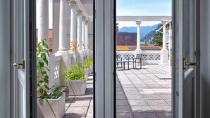 A balcony with white columns, potted plants, and a view of mountains. - Historic Villa in Como Center + 4 free parking (Como)