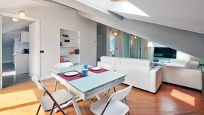 A modern, open-plan living space with a dining area, white furniture, and a skylight. - Historic Villa in Como Center + 4 free parking (Como)