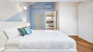 A modern bedroom with a bed, bedside table, and a view into another room. - Historic Villa in Como Center + 4 free parking (Como)